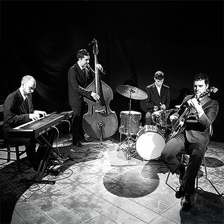 Svartvit bild av en jazzkvartett som spelar på scen