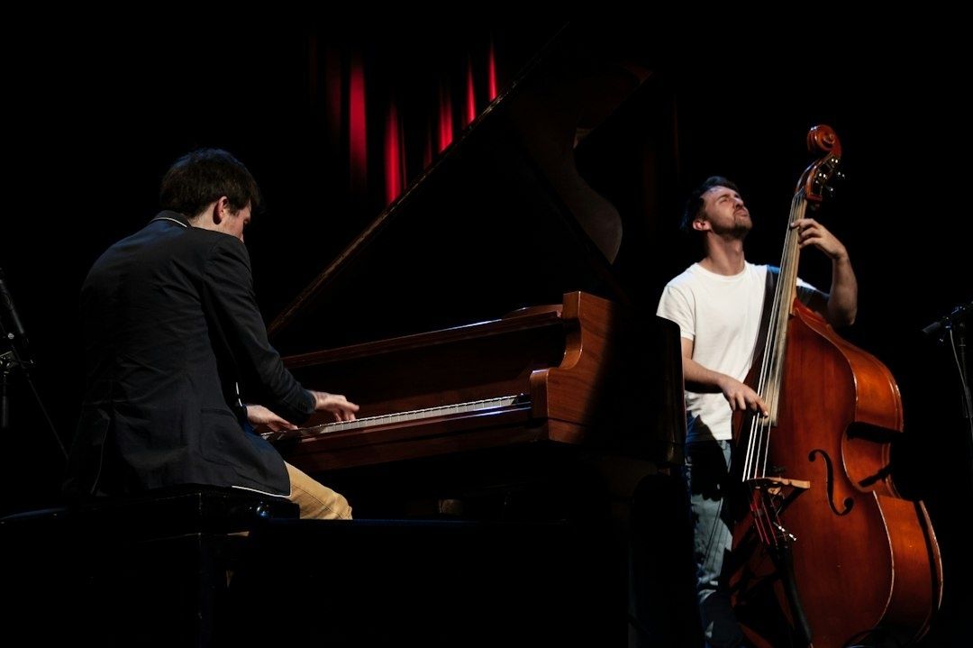 Pianist och kontrabasist spelar tillsammans på en mörk scen